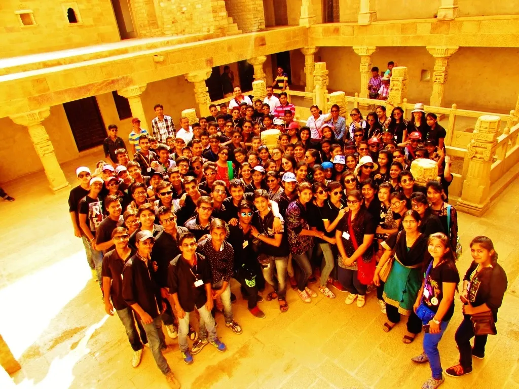 A large student group gathered inside a hotel atrium